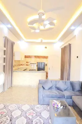 a living room with a blue couch and a ceiling at Tomorrow Land villa in Luxor