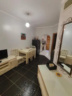 a living room with a table and a kitchen at Tony's Privy Beds by Red Sea in Hurghada