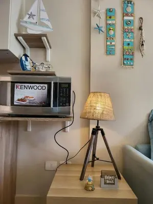 a microwave sitting on a table next to a lamp at Mangroovy Ritzy, Cerulean appartement by the pool in Hurghada