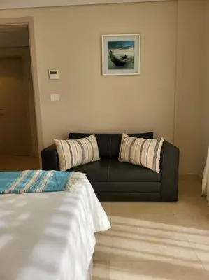 a living room with a couch and a bed at Mangroovy Ritzy, Cerulean appartement by the pool in Hurghada