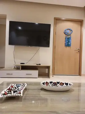 a living room with a television and two bowls on the floor at Mangroovy - 2BR Marvelous Pool View Apartment in Hurghada
