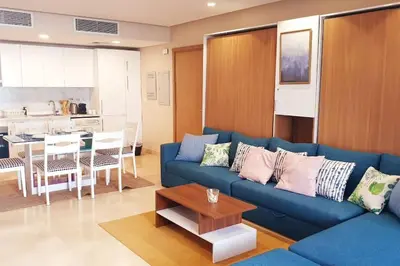 a living room with a blue couch and a table at Mangroovy - 1BR GF +2 wall beds Garden & Pool view in Hurghada