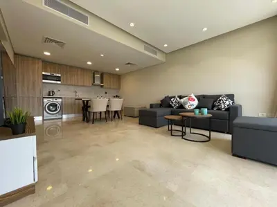 a large living room with a couch and a kitchen at Mangroovy - 1BR Ravishing Lake and Mountain View in Hurghada