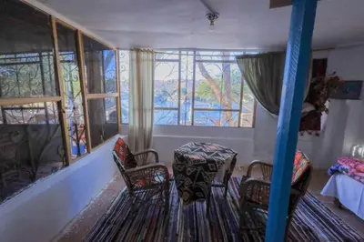 a room with a table and chairs and windows at Nubian studio in Aswan