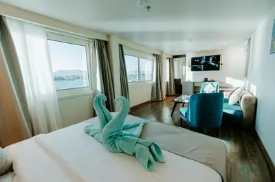a room with a bed with a stuffed animal on it at Nile Cruise 3 & 4 & 7 Nights in Luxor