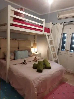 a bedroom with a bed with two bunk beds at Down-Town Kafr El Gouna 1-Bd Ground Floor in El Gouna