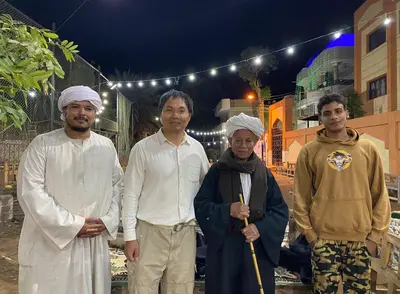 a group of men standing in front of a building at sun smile guest house᭄ꦿ in Luxor
