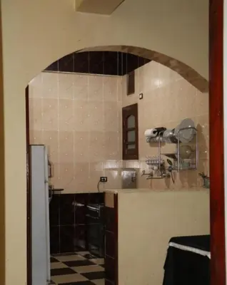 a kitchen with a counter and a tile wall at sun smile guest house᭄ꦿ in Luxor