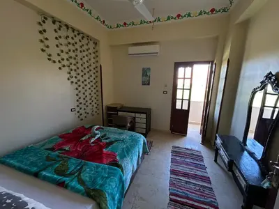 a bedroom with a bed and a mirror and a door at sun smile guest house᭄ꦿ in Luxor