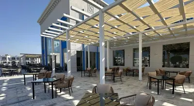 an outdoor patio with tables and chairs and awning at Casa Blue Resort in Marsa Alam City