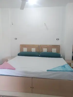 a large bed with blue pillows on top of it at Nubian Bride guest house in Aswan
