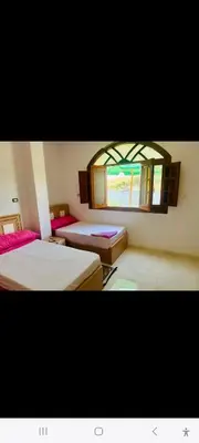 a room with two beds and a window at Nubian Bride guest house in Aswan