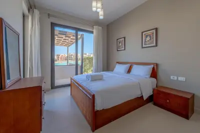 a bedroom with a bed and a large window at Brand-New Family House in Tawila El Gouna Lagoon and Pool Access in Hurghada