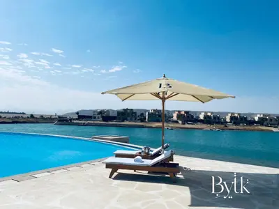 a table and umbrella next to a swimming pool at BYTK - La Casa Del Sol in Hurghada