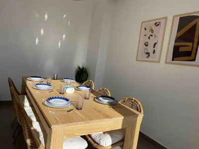 a wooden table with chairs and plates on it at 2 bd with private heated pool in Sholan 2 El Gouna in Hurghada