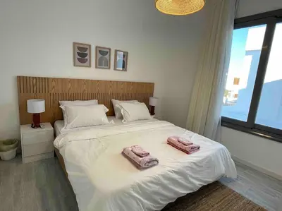 a bedroom with a large bed with two towels on it at 3bd with a private heated pool in Sholan 2 ElGouna in Hurghada