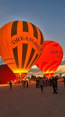 a group of people standing inront of two hot air balloons at Luxor Nile palace in Luxor
