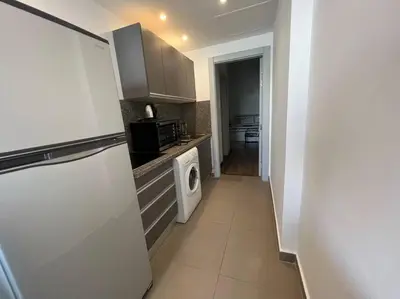 a kitchen with a refrigerator and a washer and dryer at Ground floor one bedroom overlooking the pool. in Hurghada