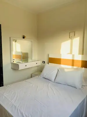 a bedroom with a white bed and a mirror at Villa Nile Rayan in Al Aqālitah