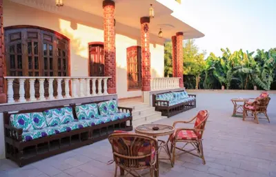 a porch of a house with chairs and tables at Villa Nile Rayan in Al Aqālitah