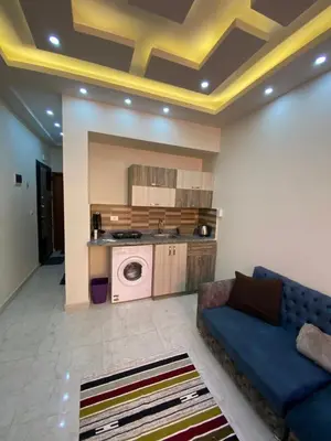 a living room with a blue couch and a kitchen at F&M Home Egypt - Apartment Hurghada in Hurghada