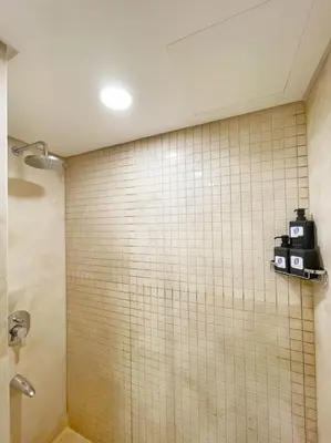 a bathroom with a tiled wall and a shower at Panoramic & Cushy 3BDR Mangroovy Free pool & Beach Access in Hurghada
