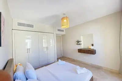 a bedroom with a white bed and a mirror at Panoramic & Cushy 3BDR Mangroovy Free pool & Beach Access in Hurghada
