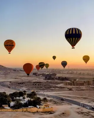 a group of hot air balloons flying over a desert at Nefertari Nile Cruise From Luxor 4&7 Nights, Every Saturday, Monday And Thursday Including tours in Luxor