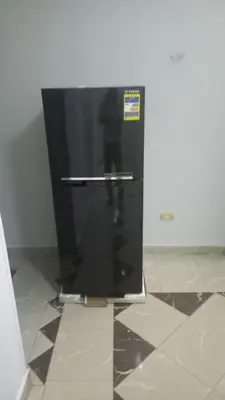 a black refrigerator sitting on a tile floor at New ikea flat 2 in Hurghada