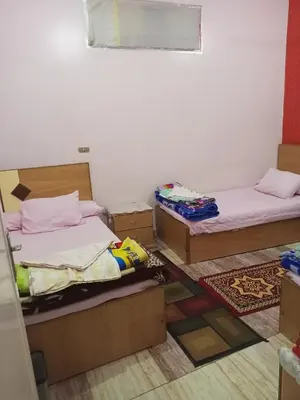 two beds in a room with boxes on the floor at NUBA ONe in Aswan