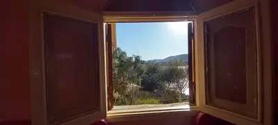 an open window with a view of a mountain at Gasser Holiday Home in Aswan