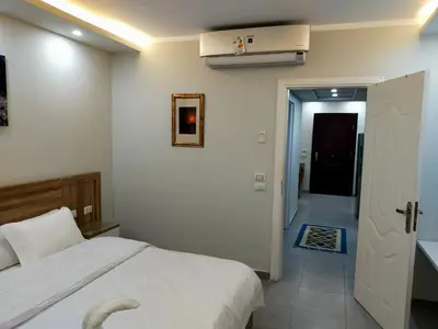 a bedroom with a white bed and a hallway at Sweet Home in Hurghada