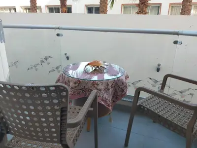 a table and chairs on a balcony with a cat on it at Sweet Home in Hurghada