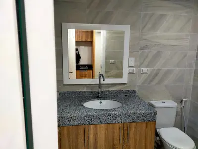 a bathroom with a sink and a toilet and a mirror at Sweet Home in Hurghada