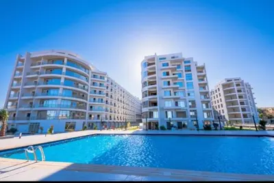 a swimming pool in front of two tall buildings at Sweet Home in Hurghada