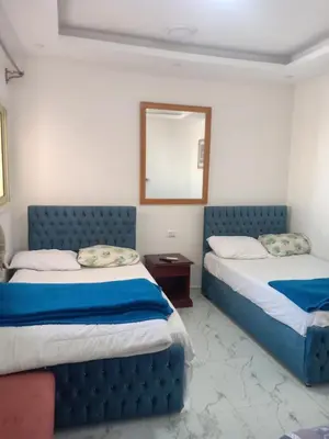 a bedroom with two beds and a mirror at A two-room chalet in the village of Lale Land, Mirage Bay, Ecopark in Hurghada