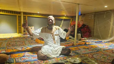 a man sitting on top of a bed at Abo Tamem Guest House in Aswan