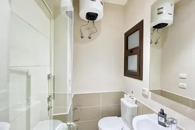 a bathroom with a toilet and a shower and a sink at Homelike & Sunny 1 BDR Cyan El Gouna in Hurghada
