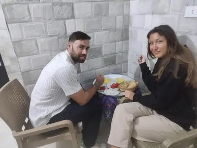 a man and woman sitting at a table with a plate of food at NUBIAN MONALIZA guest house in Aswan