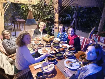 a group of women sitting around a table eating food at Bedouin Lodge Luxor in Luxor