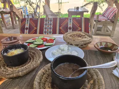 a table with bowls of food and plates of food at Bedouin Lodge Luxor in Luxor