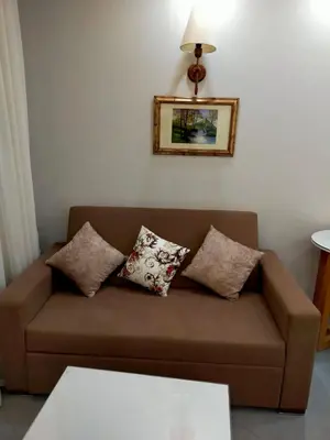 a brown couch with pillows in a living room at Happy Home in Hurghada