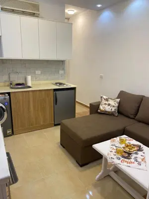 a living room with a couch and a kitchen at Beautiful apartment near sea 1+1 Dream Beach in Hurghada