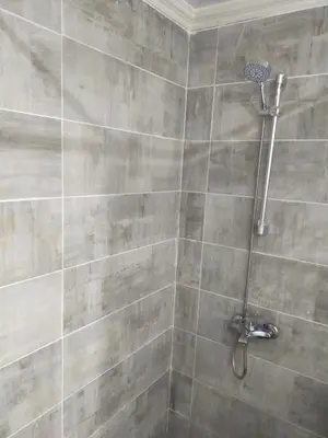 a bathroom with a shower with a tiled wall at شقة احلامك على البحر in Hurghada