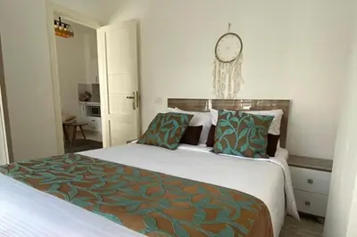 a bedroom with a large bed with a clock on the wall at 1 Bed Apartment - Balcony Pool Parking in Hurghada