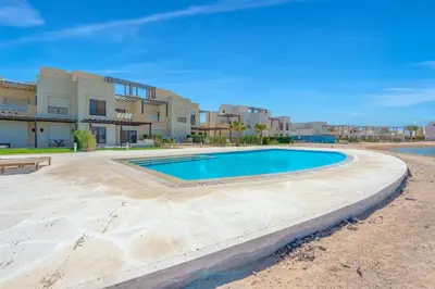 a swimming pool in front of a building at NEW! Gouna, Cyan Cozy 3BR Townhouse Lagoon & Pool in Hurghada