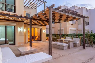 a patio with a wooden pergola and benches at NEW! Gouna, Cyan Cozy 3BR Townhouse Lagoon & Pool in Hurghada