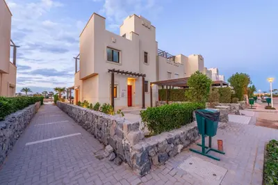 a building with a stone wall next to a street at NEW! Gouna, Cyan Cozy 3BR Townhouse Lagoon & Pool in Hurghada