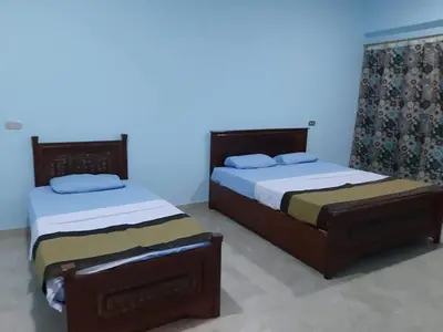 two beds sitting next to each other in a bedroom at Nile Roof Hotel& Restaurant in Luxor