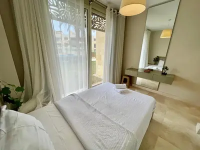 a white bed in a room with a large window at Mangrove m3-1b-02 in Hurghada